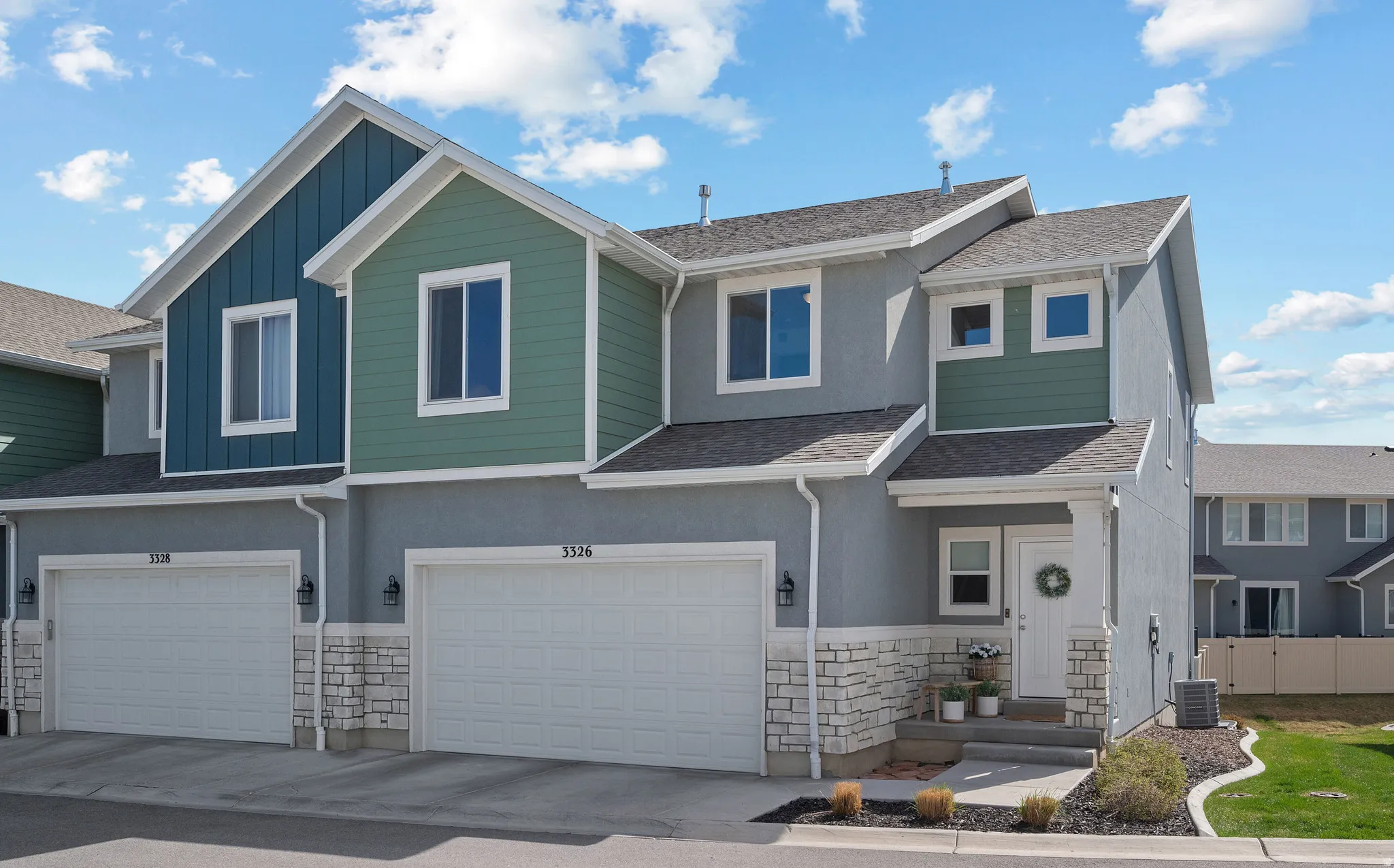 View of front of property featuring a garage, stone siding, board and batten siding, roof with shingles, and stucco siding