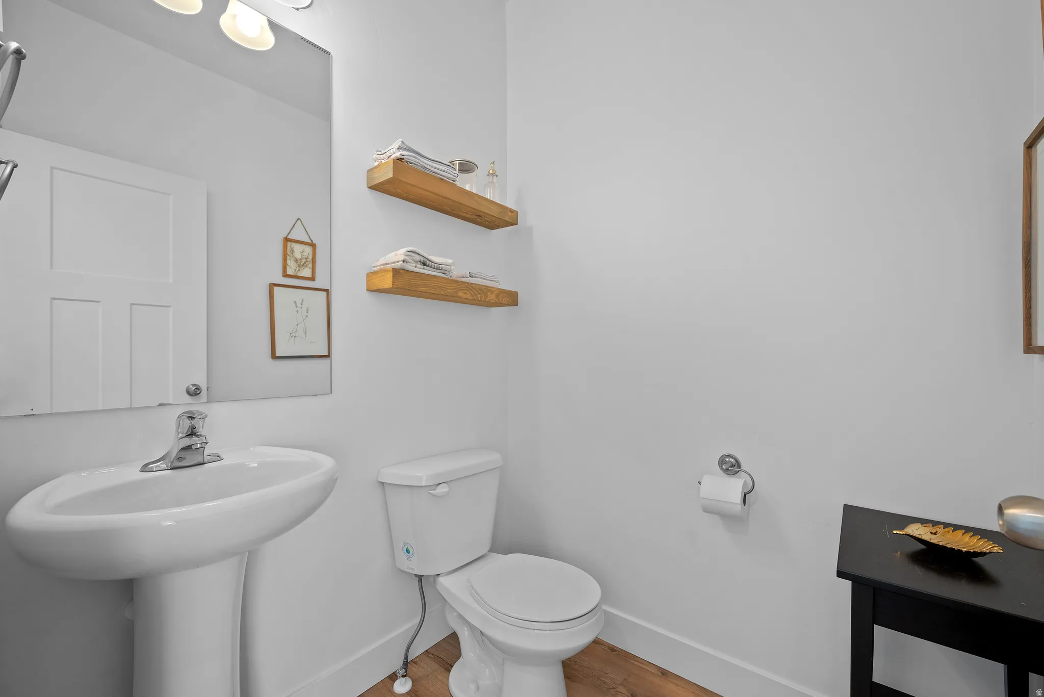 Half bath featuring baseboards and light wood-style flooring