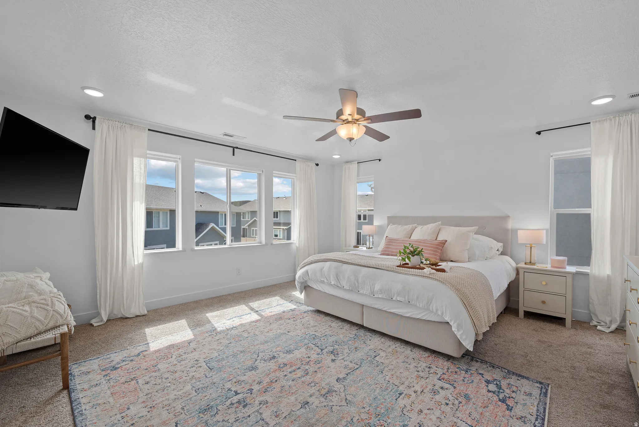Carpeted bedroom featuring a ceiling fan, recessed lighting, and a textured ceiling