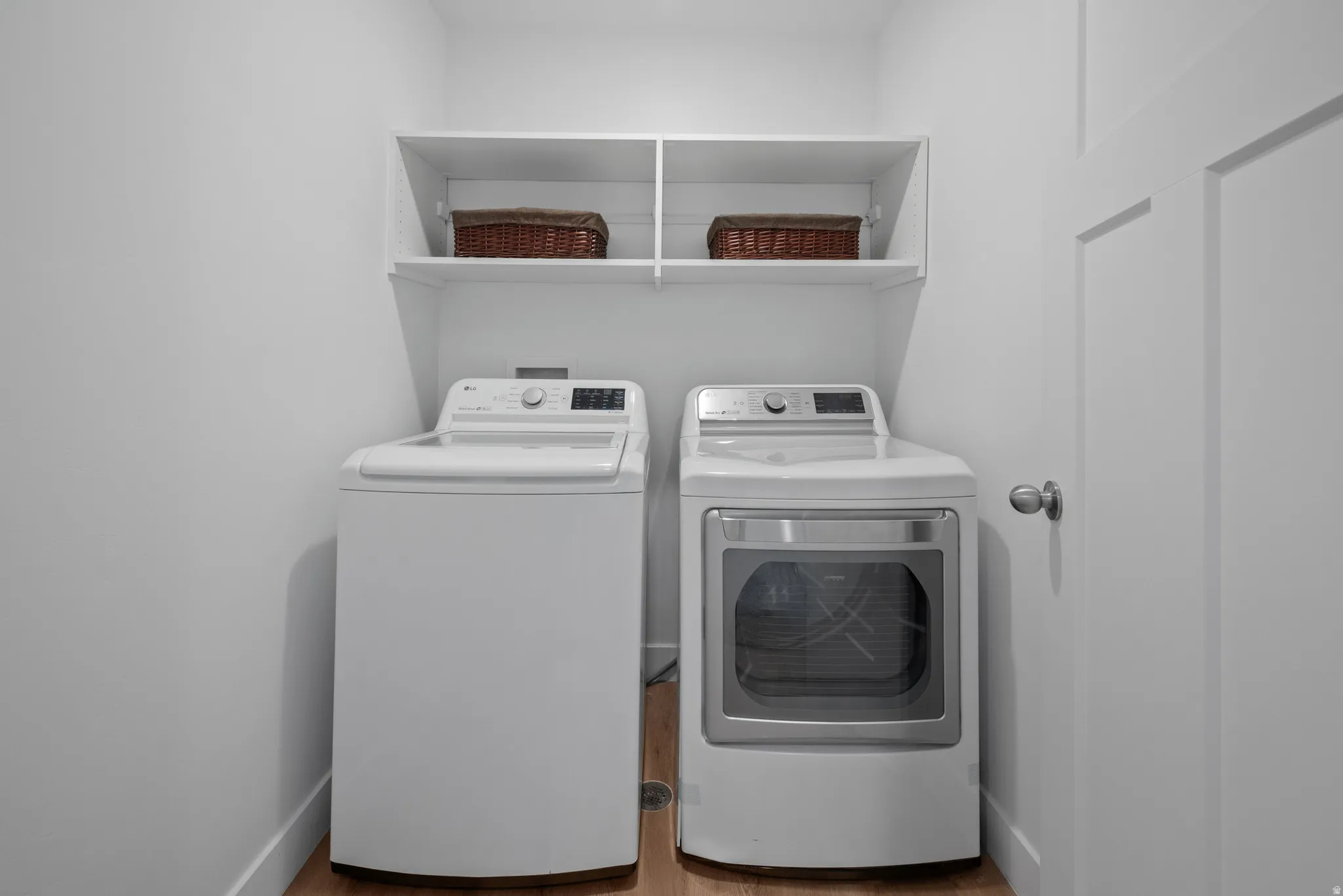 Laundry area featuring washer and dryer and light wood finished floors