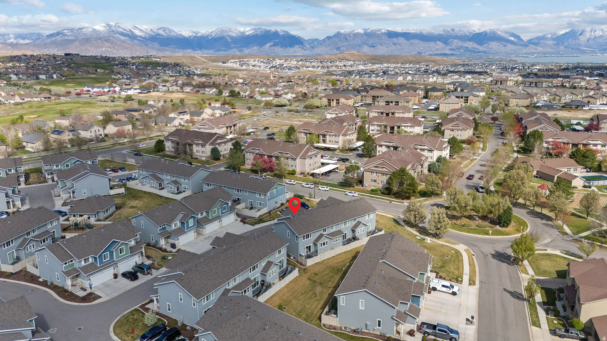 Aerial view of property and surrounding area with mountains and nearby suburban area
