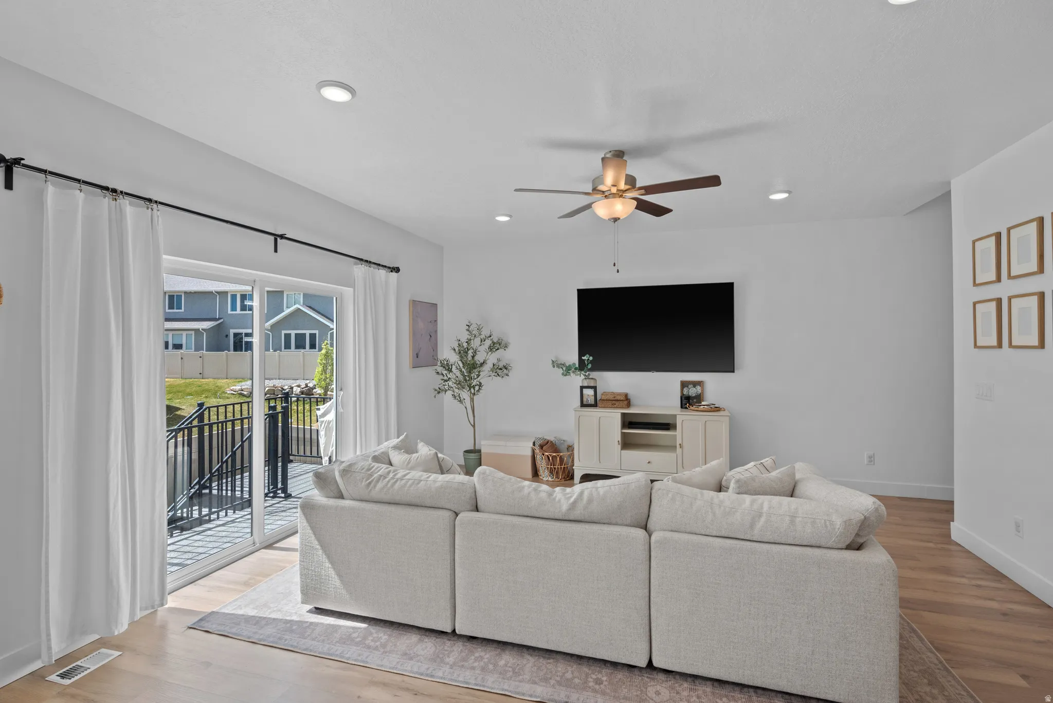 Living room featuring ceiling fan, light wood-style flooring, and recessed lighting
