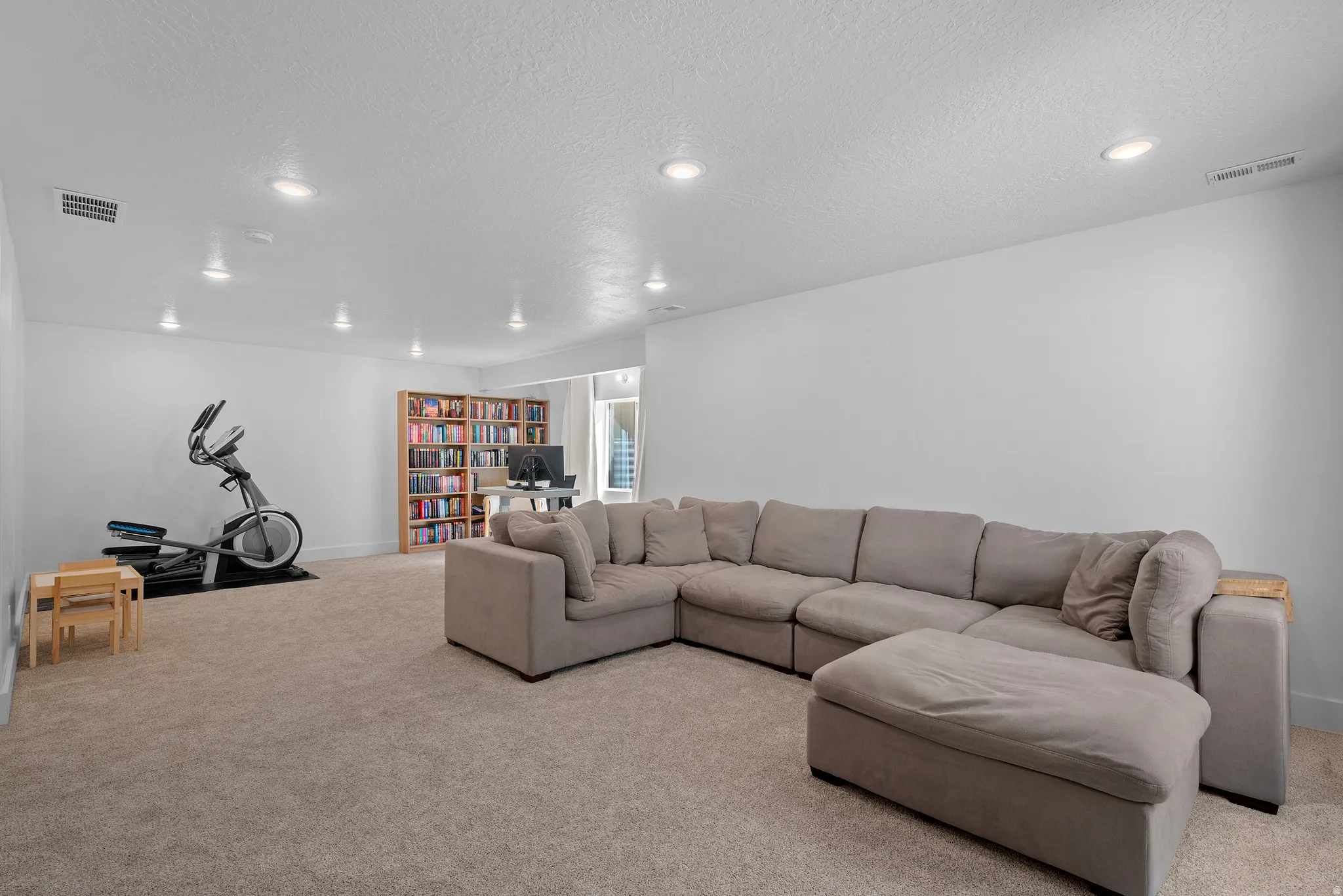 Living room featuring carpet floors, a textured ceiling, and recessed lighting