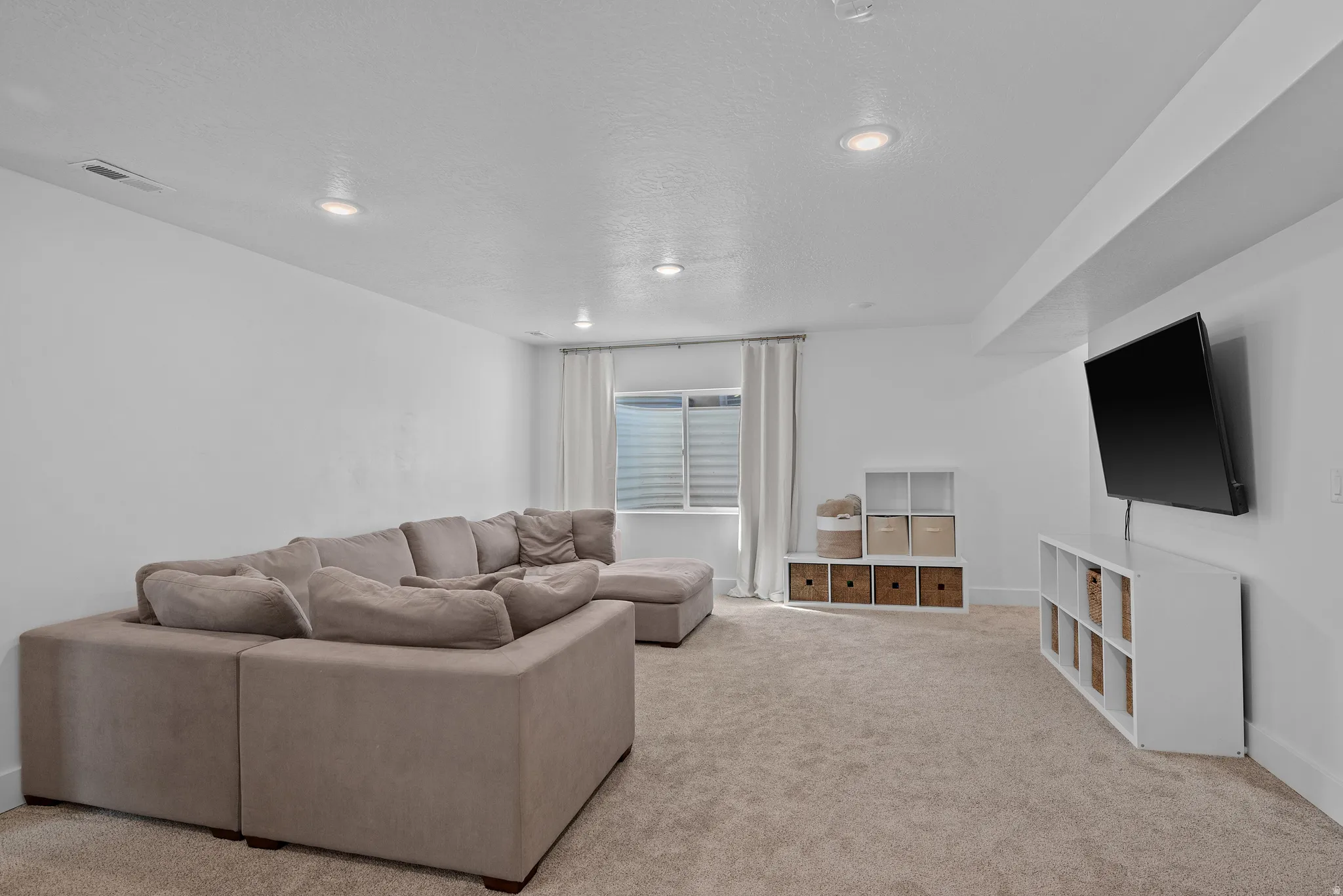 Living room with light carpet and recessed lighting