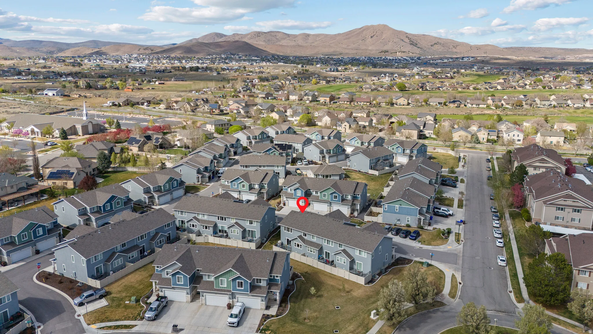 Aerial view of property and surrounding area with mountains and nearby suburban area