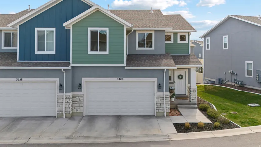 View of front of property with a shingled roof, stone siding, board and batten siding, and an attached garage