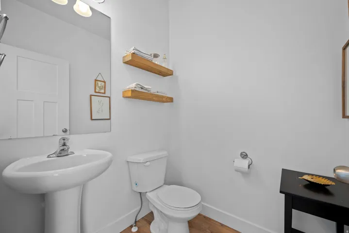 Half bath featuring baseboards and light wood-style flooring