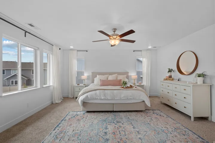 Bedroom featuring light colored carpet, a ceiling fan, and recessed lighting