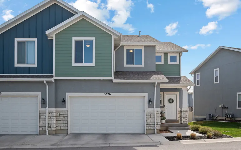 View of front of property featuring a shingled roof, board and batten siding, and stone siding