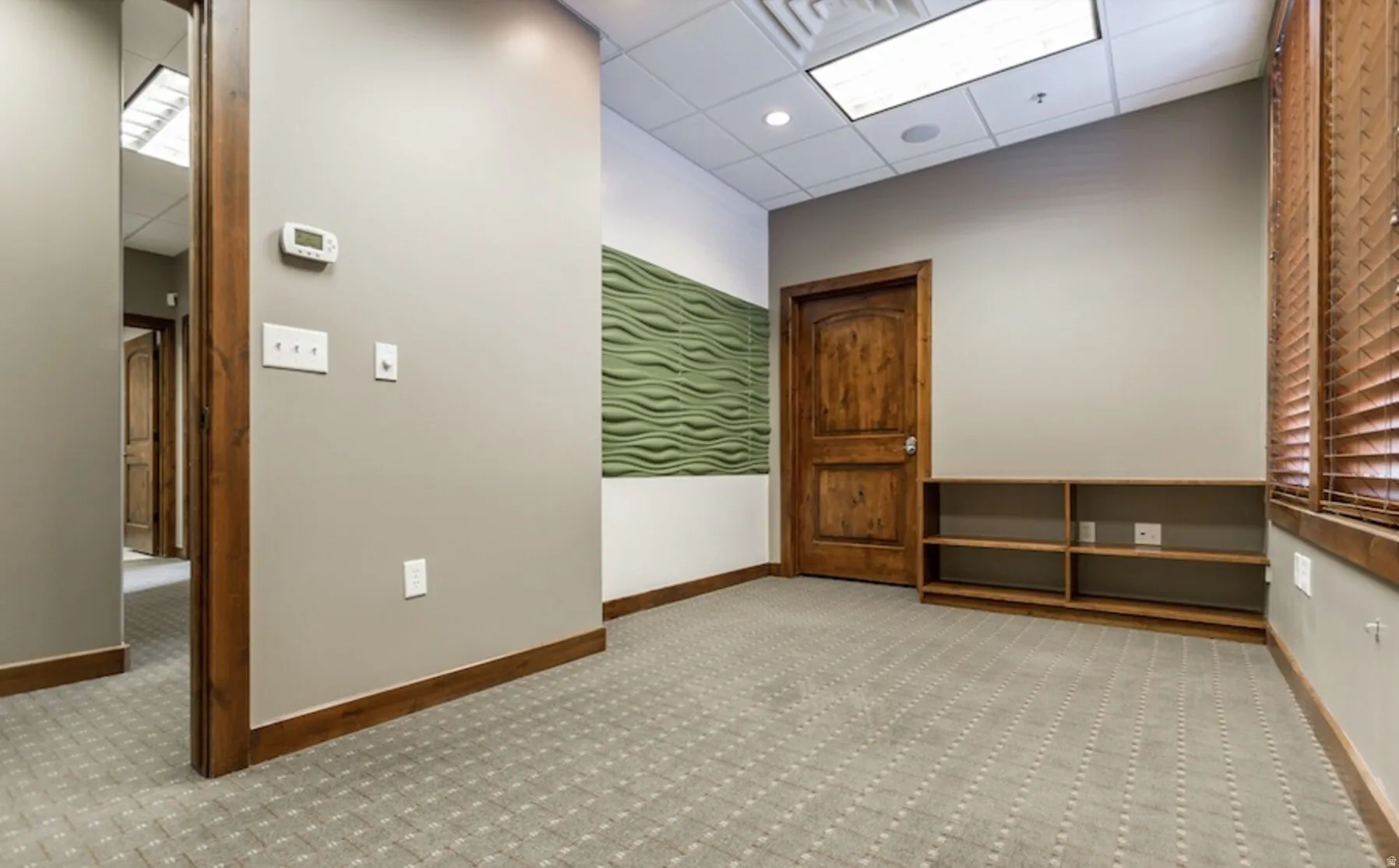 Spare room with a high drop ceiling, light colored carpet, and recessed lighting