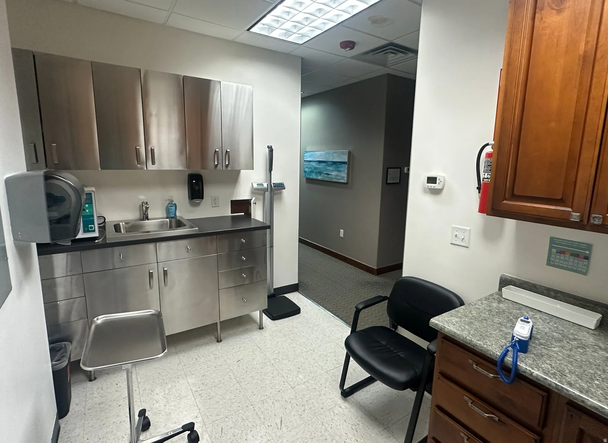 Misc room with a drop ceiling and light floors