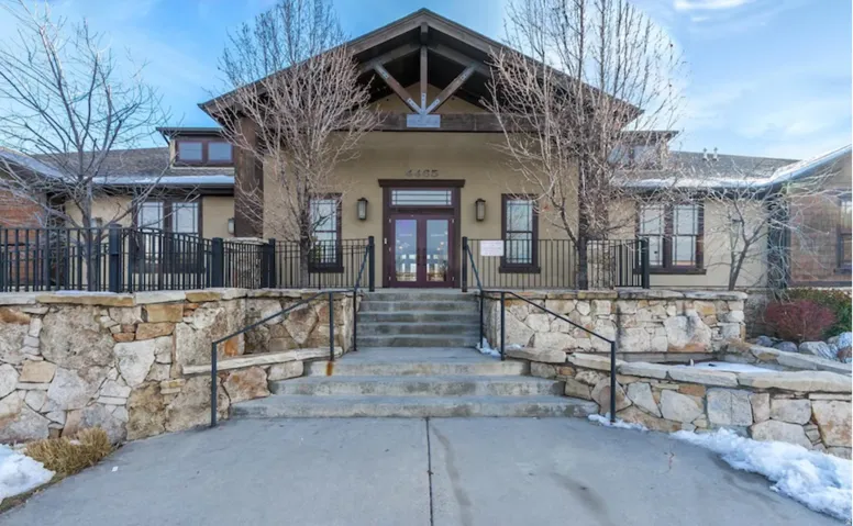 View of exterior entry with french doors, stucco siding, and covered porch