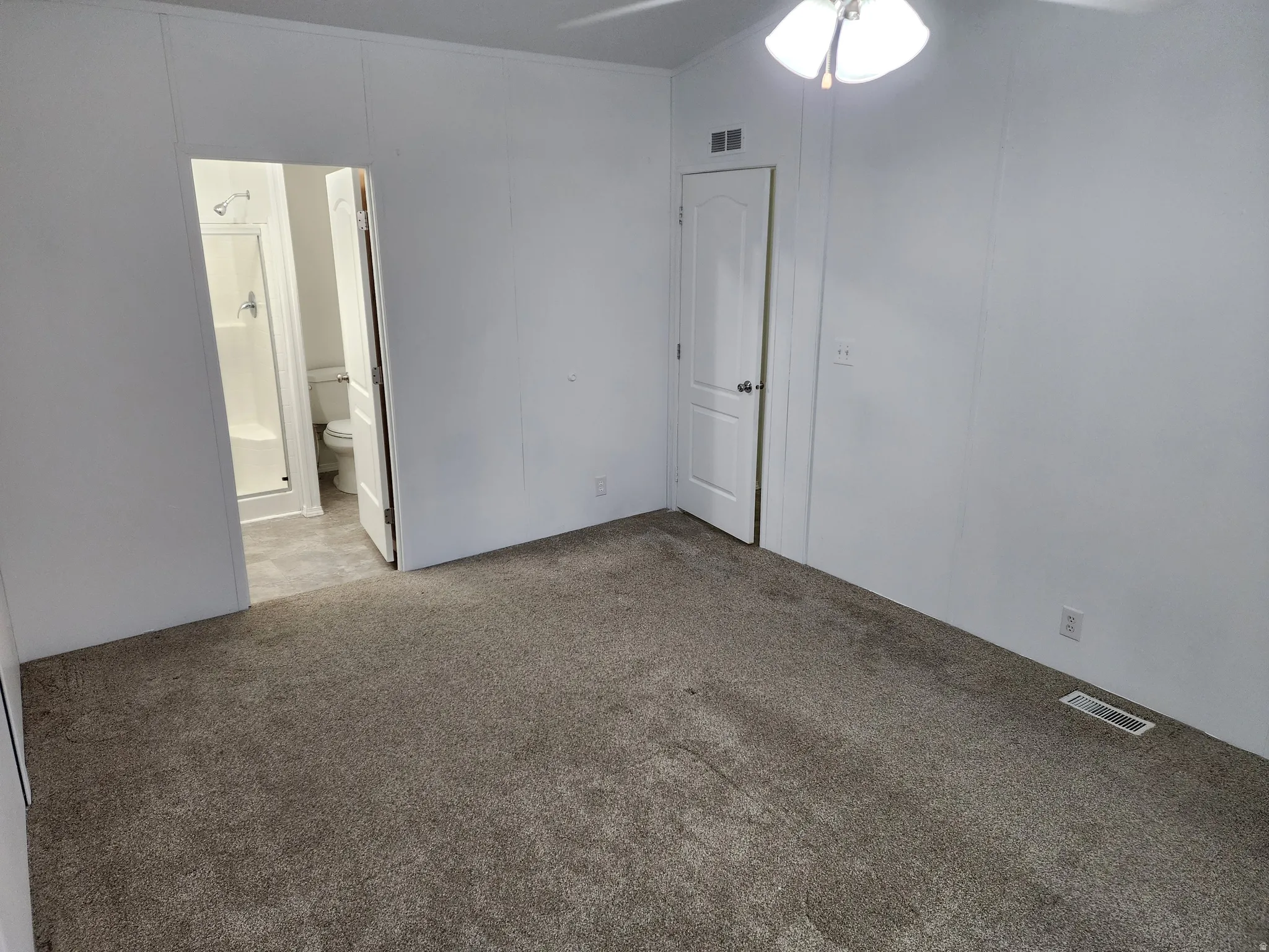 Unfurnished bedroom with carpet and a ceiling fan