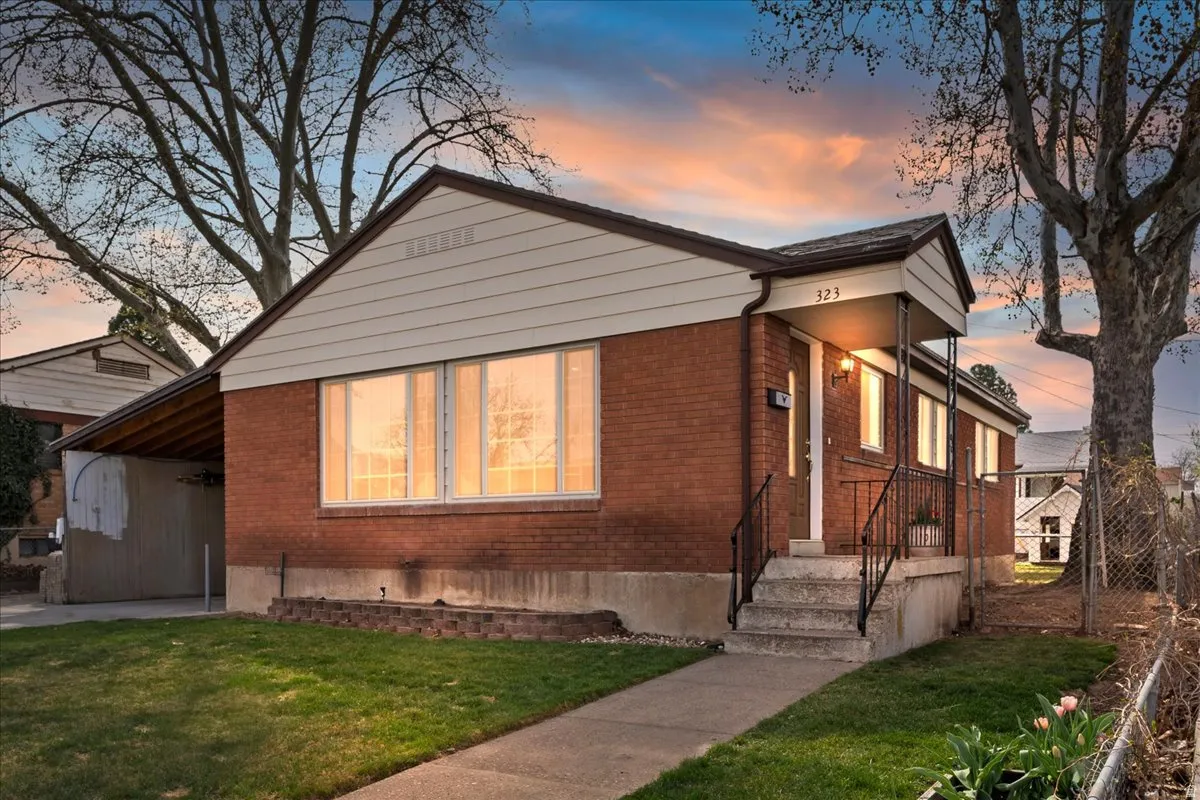 Bungalow-style home featuring brick siding and a front lawn