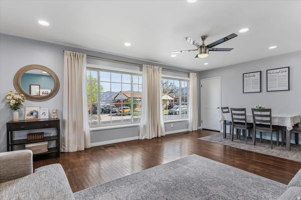 Dining space with dark wood-type flooring, a ceiling fan, plenty of natural light, and recessed lighting