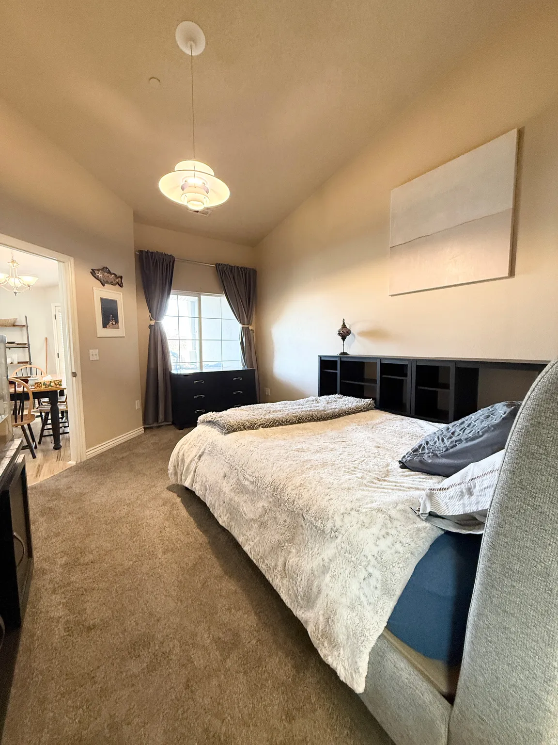 Carpeted bedroom featuring baseboards and hanging lights