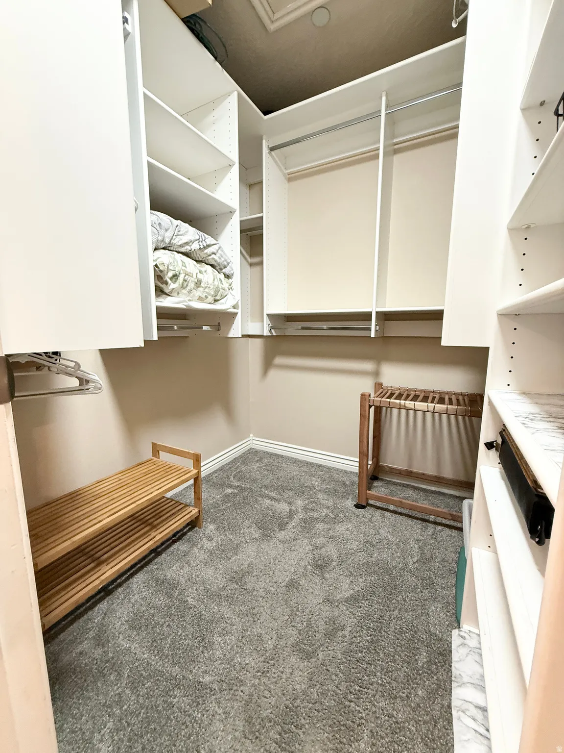 Walk in closet featuring dark carpet