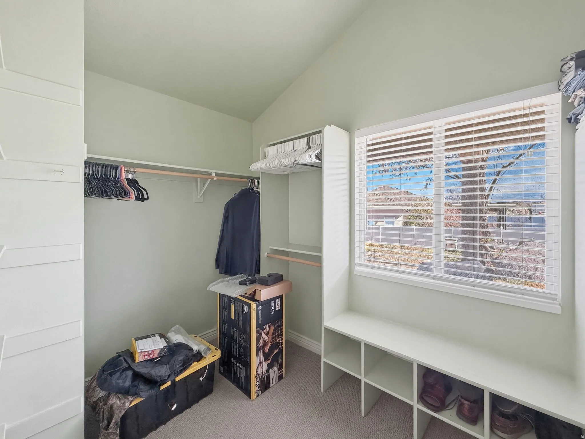 Walk in closet with carpet flooring and lofted ceiling