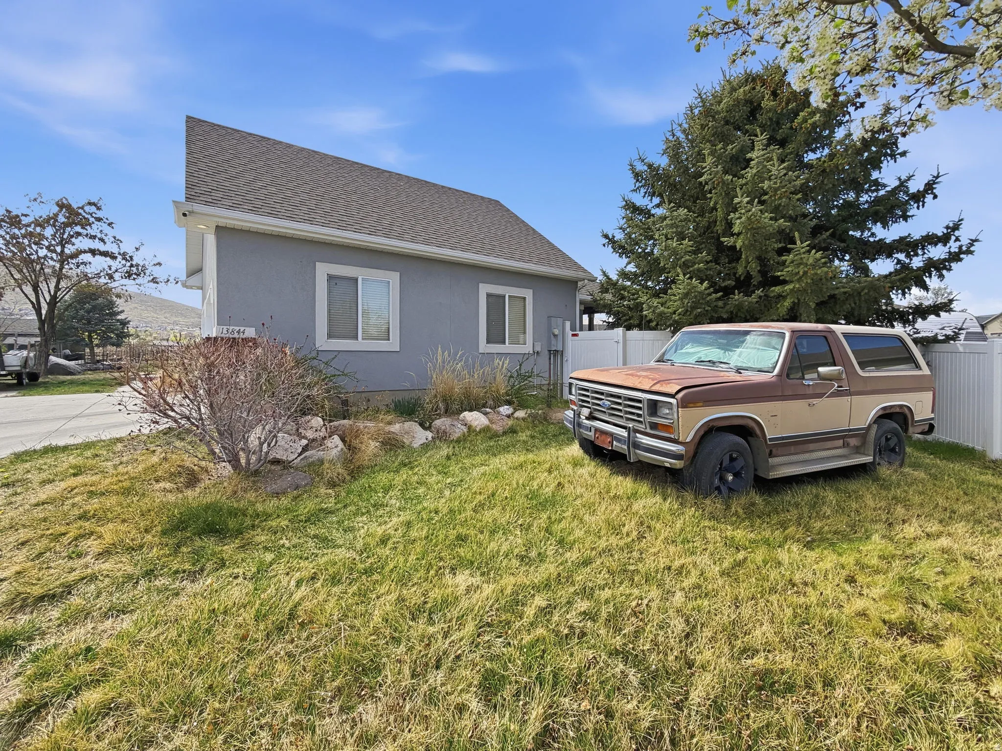 View of side of home with stucco siding and roof with shingles