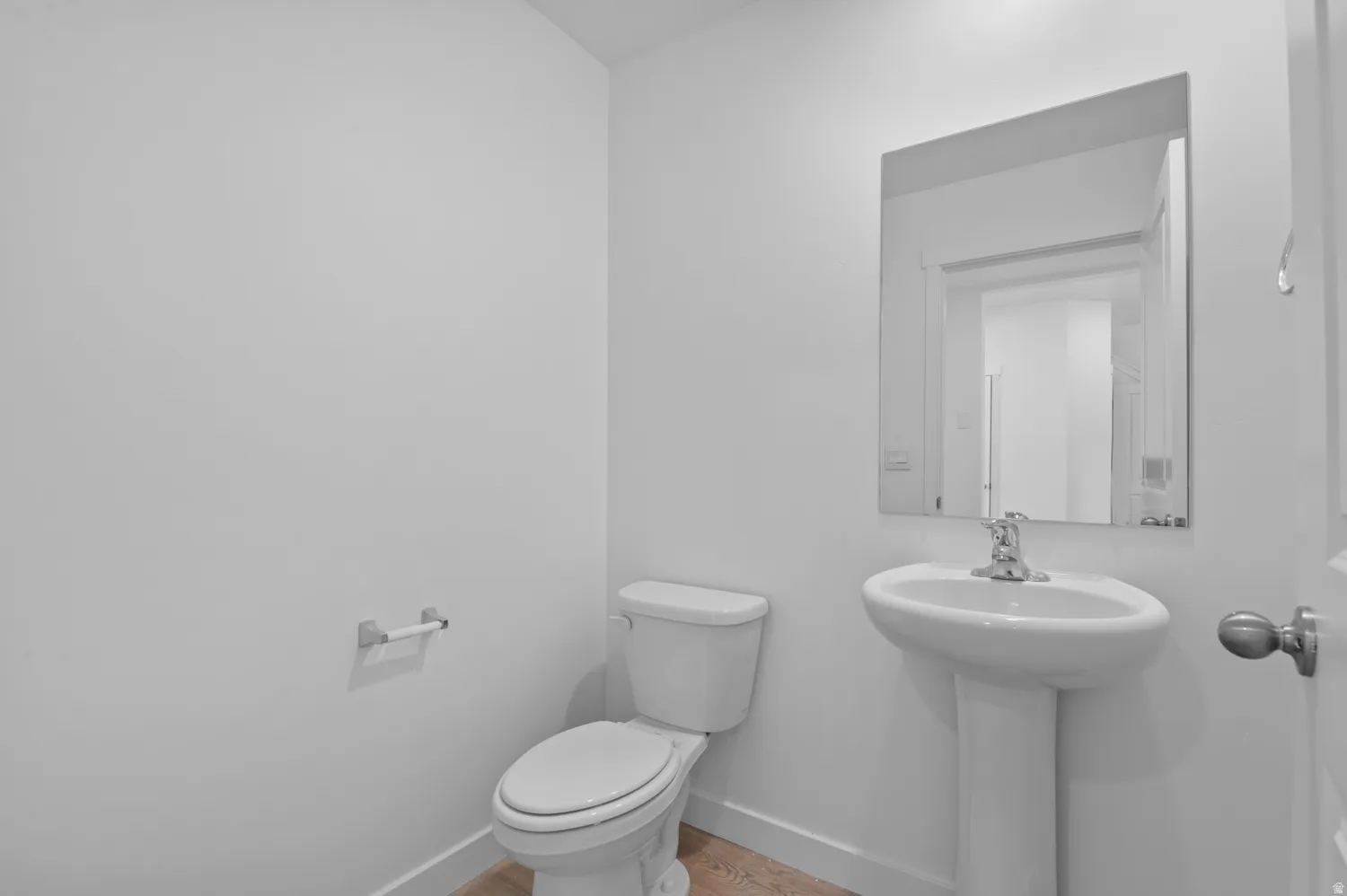 Half bath featuring toilet and light wood-style floors