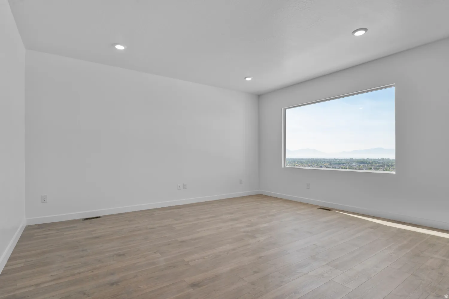 Spare room with light wood-style floors and recessed lighting