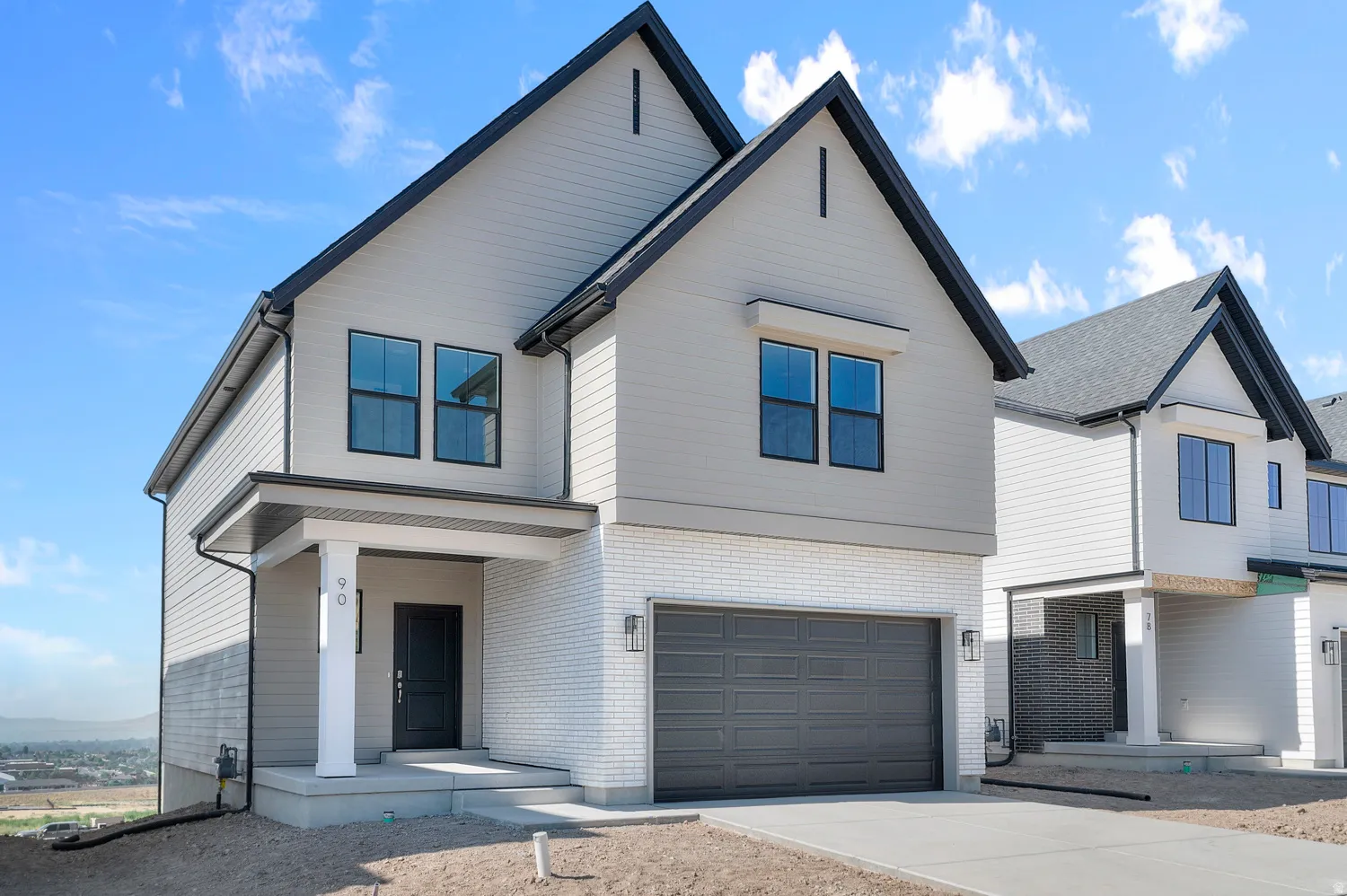 View of front of home with a garage, concrete driveway, and brick siding