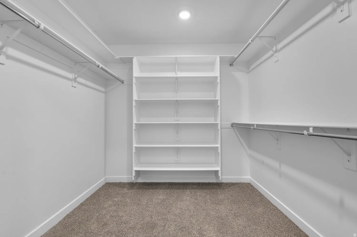 Walk in closet featuring dark carpet