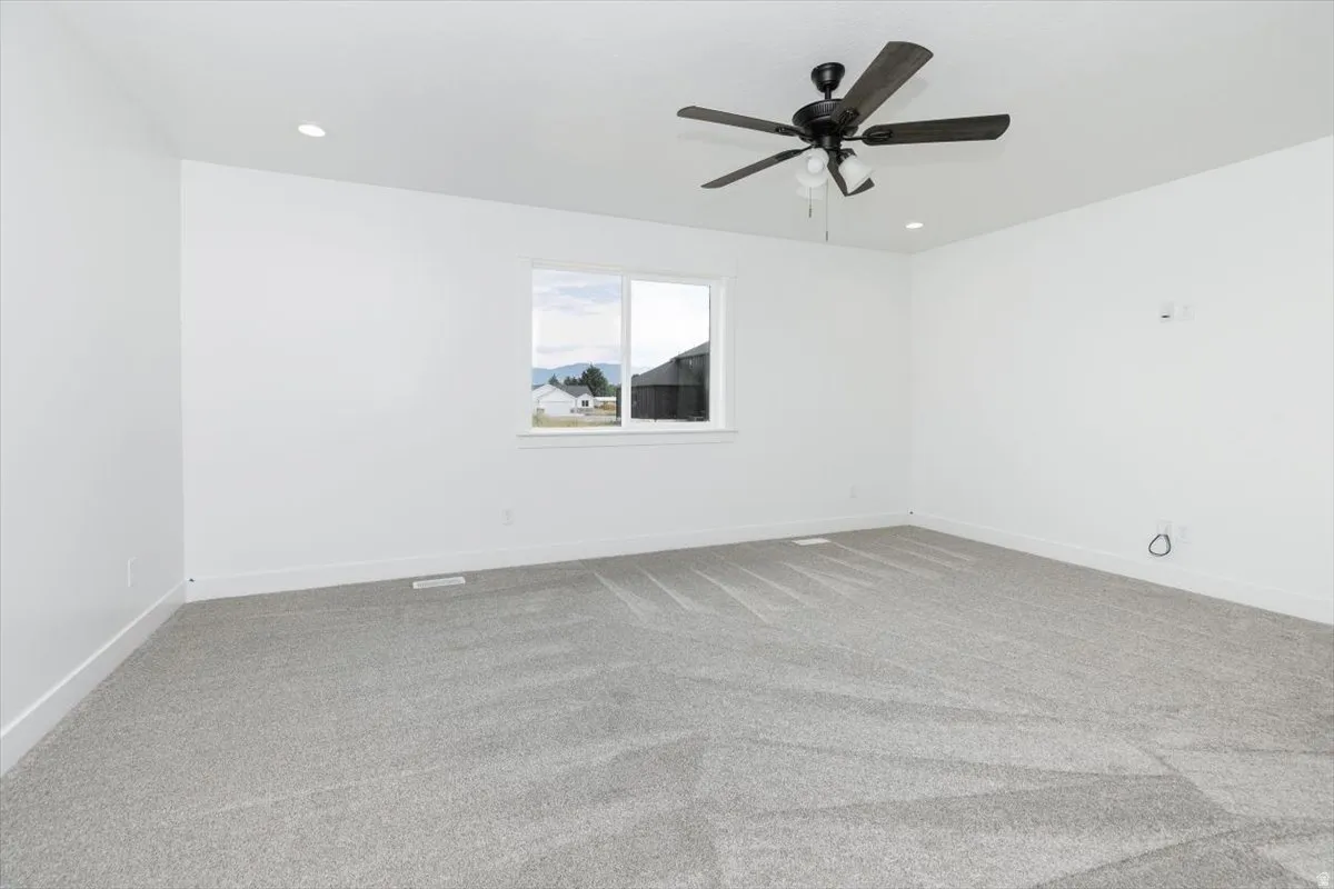 Unfurnished room with light colored carpet, ceiling fan, and recessed lighting