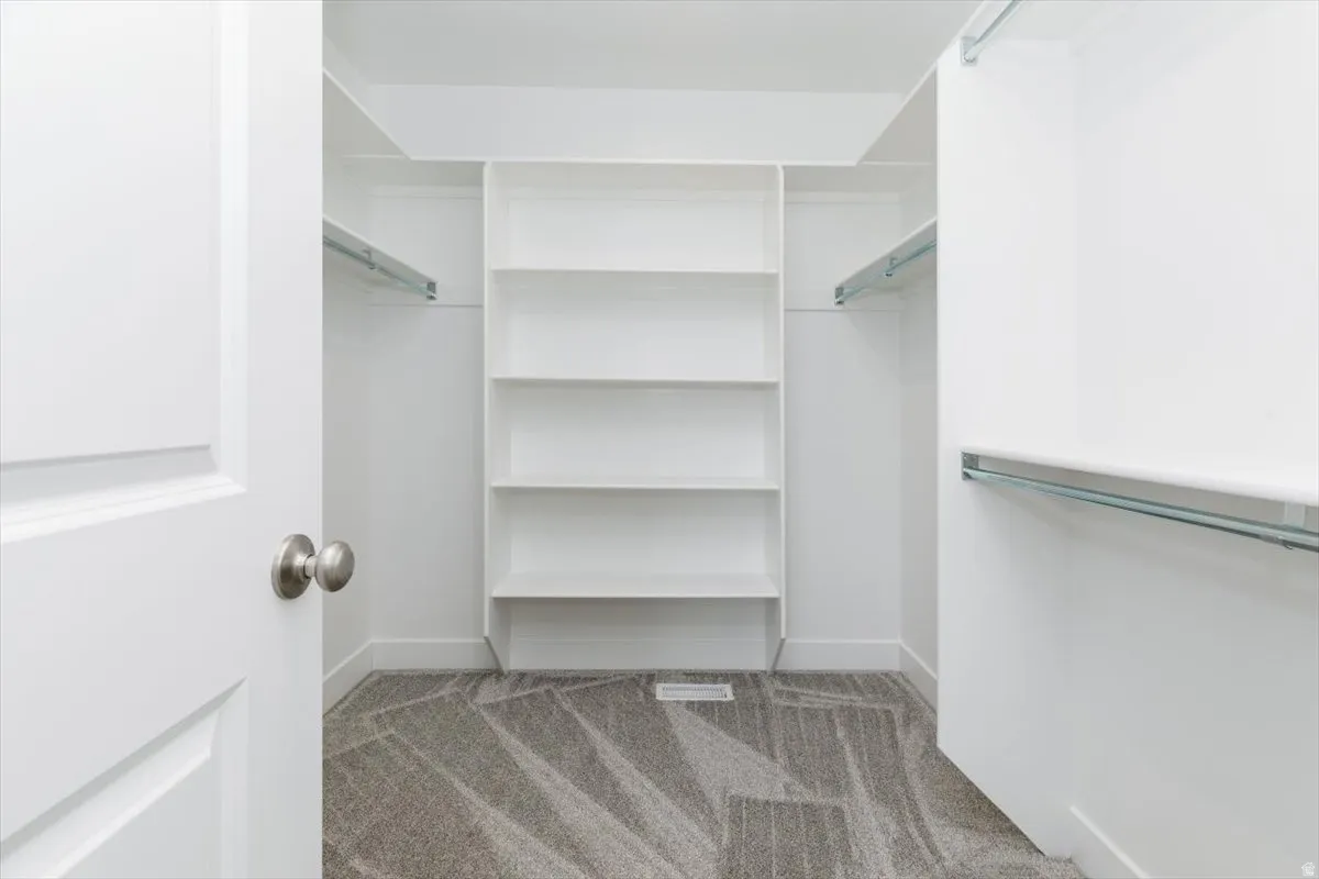 Walk in closet featuring light carpet