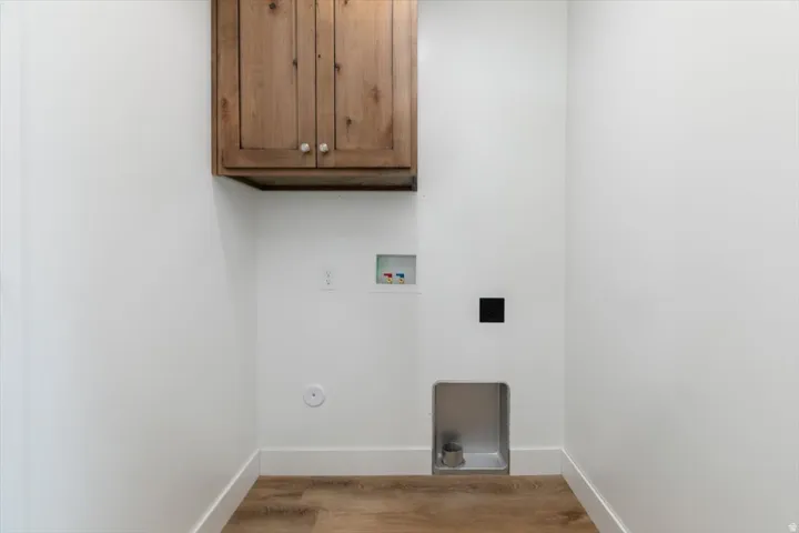 Laundry area featuring cabinet space, light wood-style flooring, and hookup for a washing machine