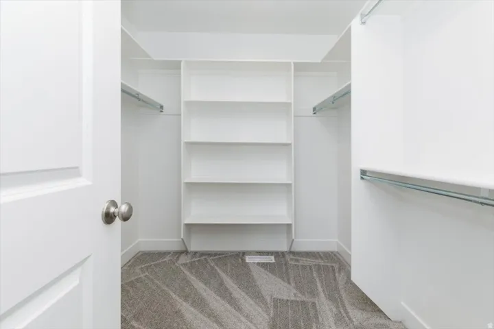 Walk in closet featuring light carpet