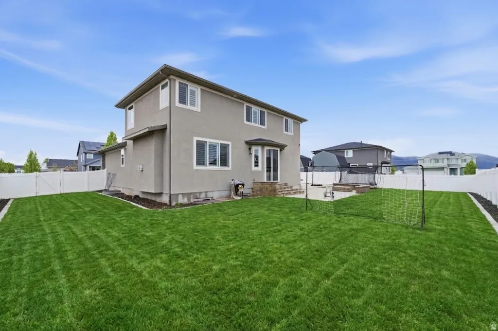 AI Enhanced Green Lawn - Rear view of house featuring a fenced backyard, stucco siding, and a gate