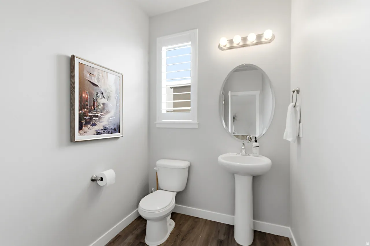 Bathroom with toilet and dark wood-style flooring