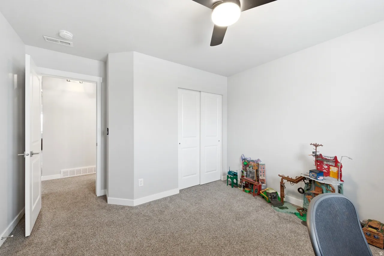 Playroom with light colored carpet and a ceiling fan