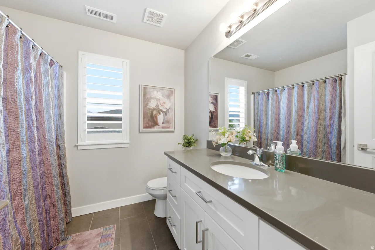 Bathroom with vanity, a shower with shower curtain, and dark tile patterned flooring