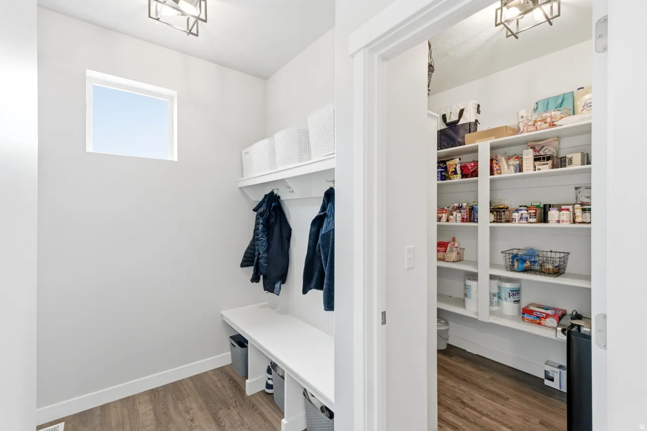 Mudroom with dark wood-style flooring and suspended lighting