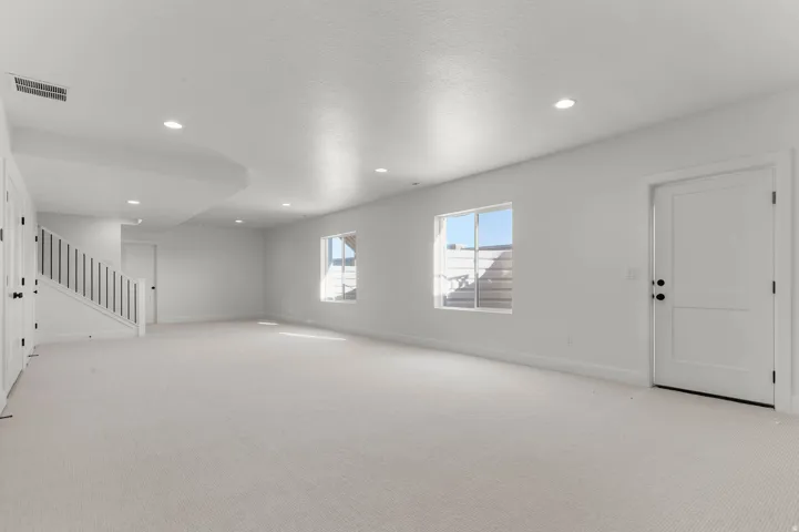 Spare room featuring recessed lighting, light colored carpet, and a textured ceiling