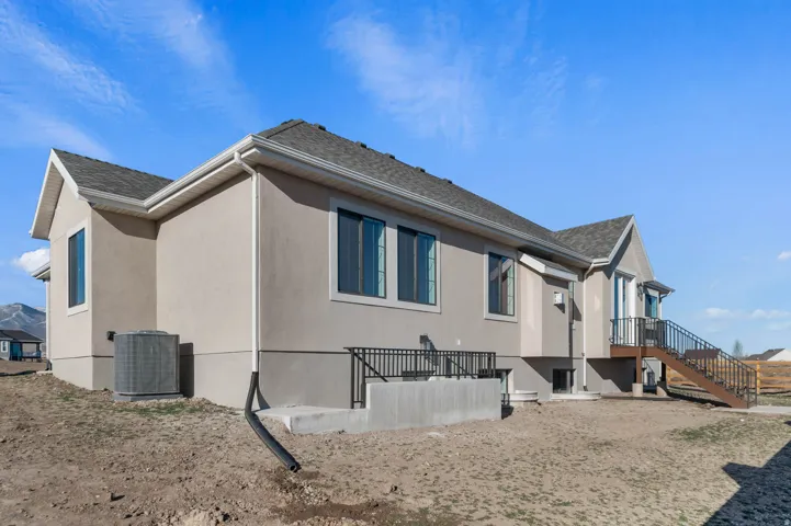 View of property exterior featuring stucco siding and a shingled roof