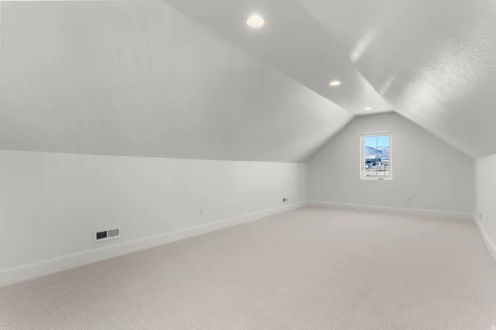 Bonus room with carpet floors and recessed lighting