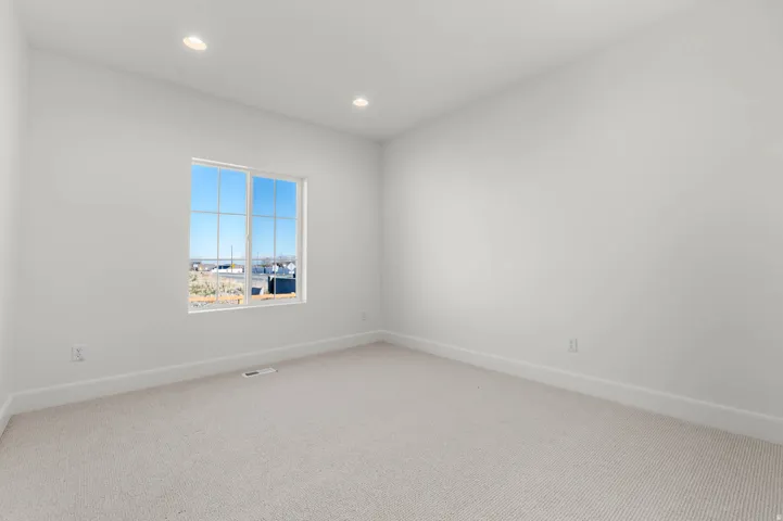 Unfurnished room with light colored carpet and recessed lighting