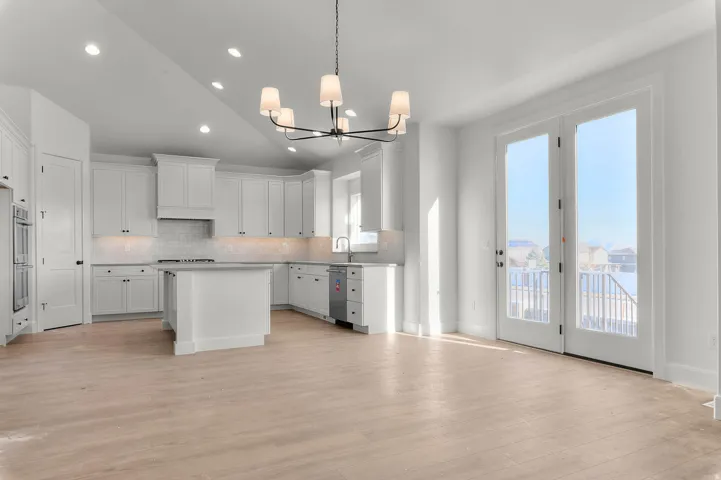 Kitchen with a center island, vaulted ceiling, hanging lights, backsplash, and light countertops