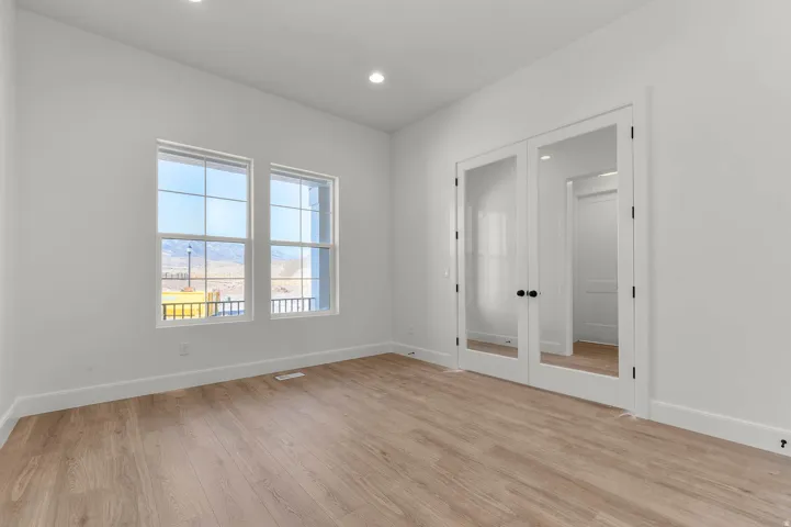 Unfurnished room with french doors, light wood-type flooring, and recessed lighting