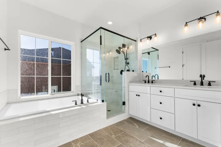 Bathroom with double vanity, a stall shower, and a garden tub