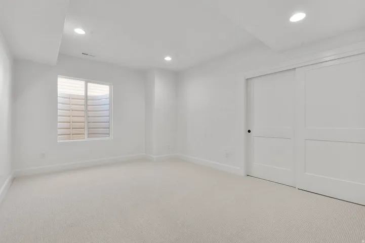 Unfurnished bedroom featuring light colored carpet, a closet, and recessed lighting