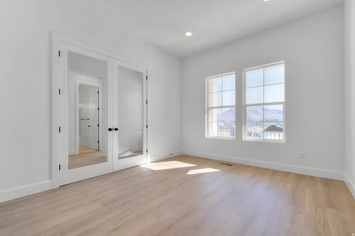 Spare room with french doors, light wood finished floors, and recessed lighting