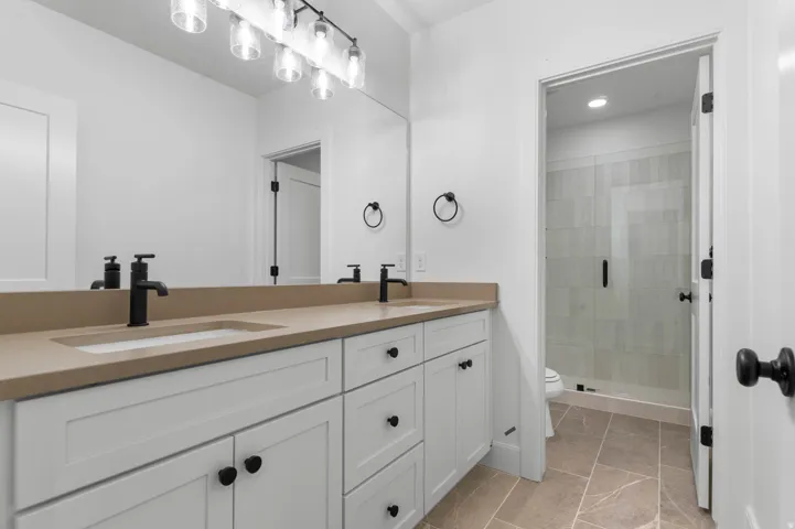Bathroom with double vanity and a stall shower