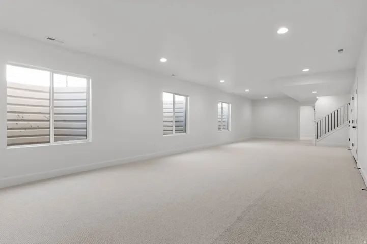 Spare room featuring recessed lighting and light carpet