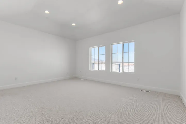 Empty room with carpet, recessed lighting, and lofted ceiling