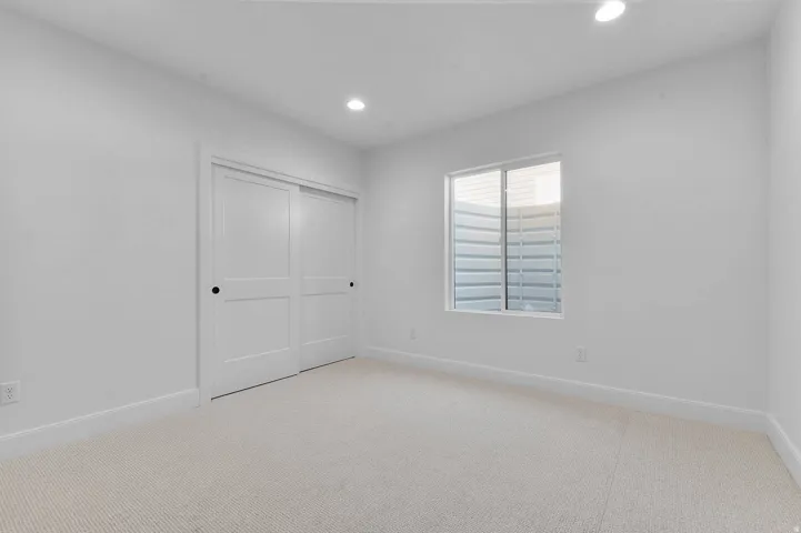 Unfurnished bedroom with carpet, recessed lighting, and a closet
