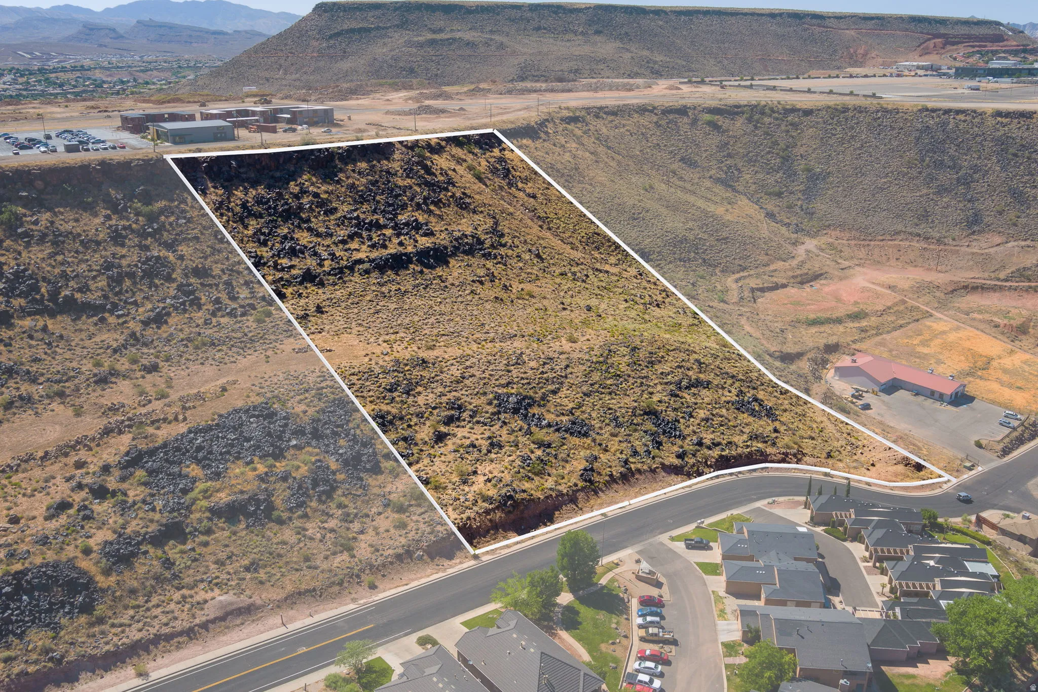 Aerial view of property's location with property boundaries highlighted and a mountain backdrop